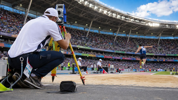 Geodet obavlja sudačku izmjeru na atletskom stadionu tijekom natjecanja